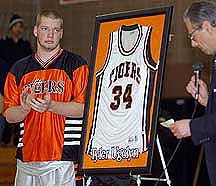 Ridgefield High School basketball player Daryl Yankowski, left, watches school Principal Ralph Ellis retire the jersey of former player and World Trade Center victim Tyler Ugolyn.